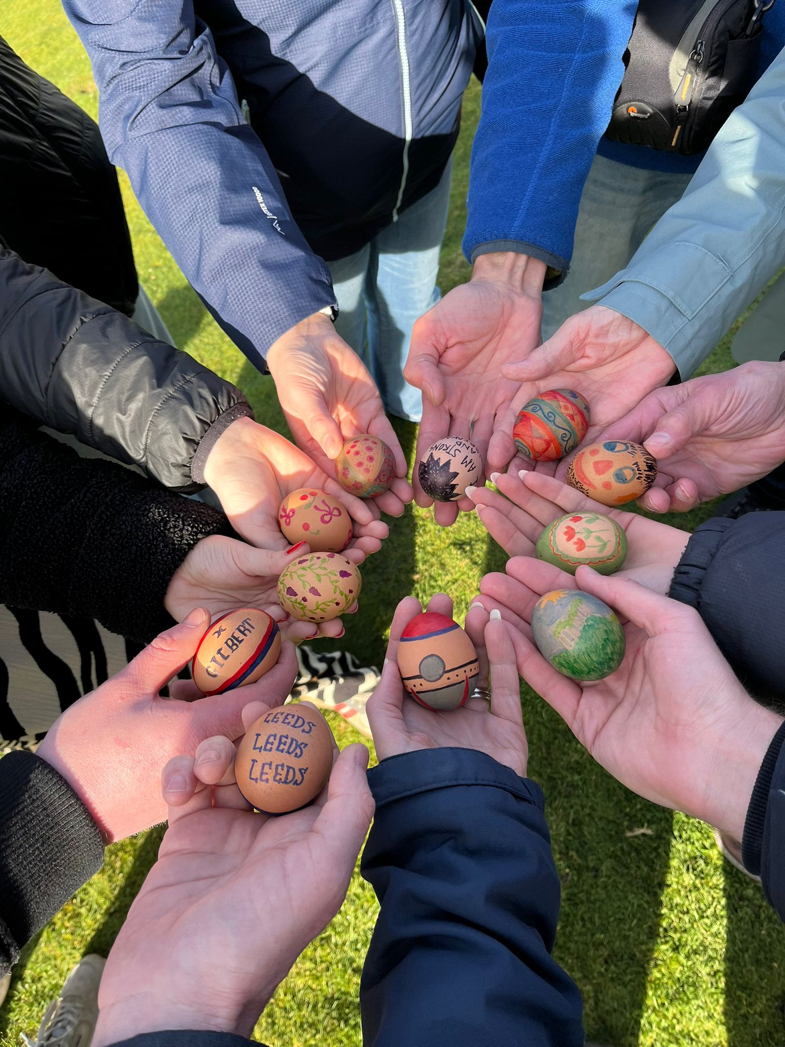 A photo of eleven hand-decorated eggs in a circle